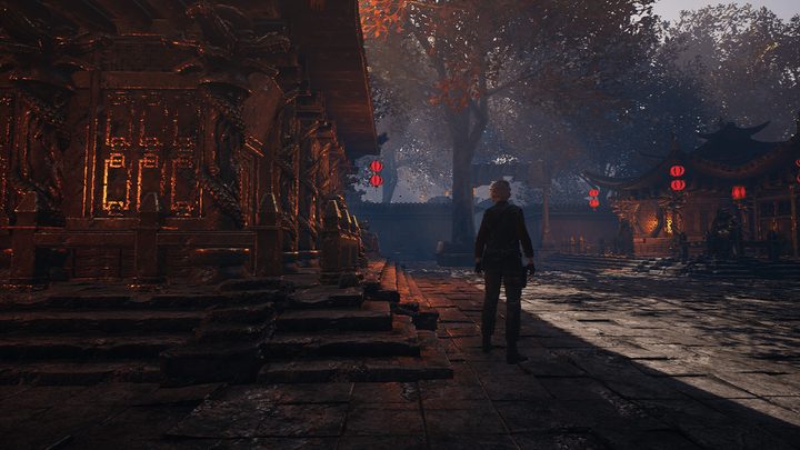 A Far Eastern temple courtyard lit by red lanterns